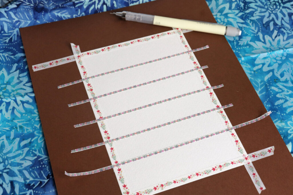 Image contains a piece of watercolor paper secured to a piece of cardstock and divided into six sections with washi tape.