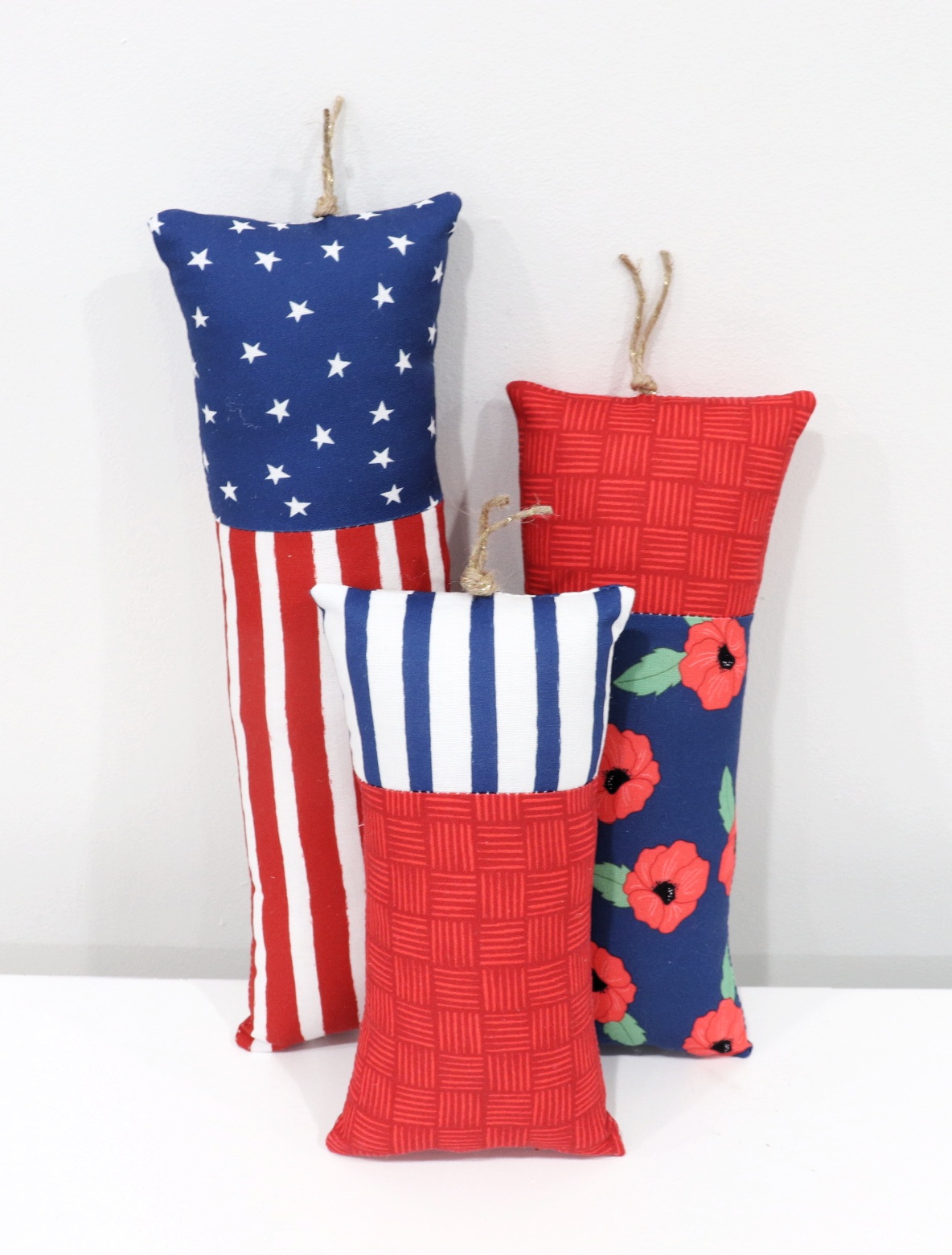 Image contains three plush fabric firecrackers made from patriotic fabric.