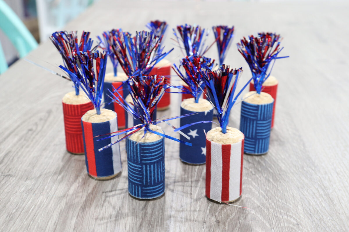 Image contains a dozen cork firecrackers sitting on a wooden table.