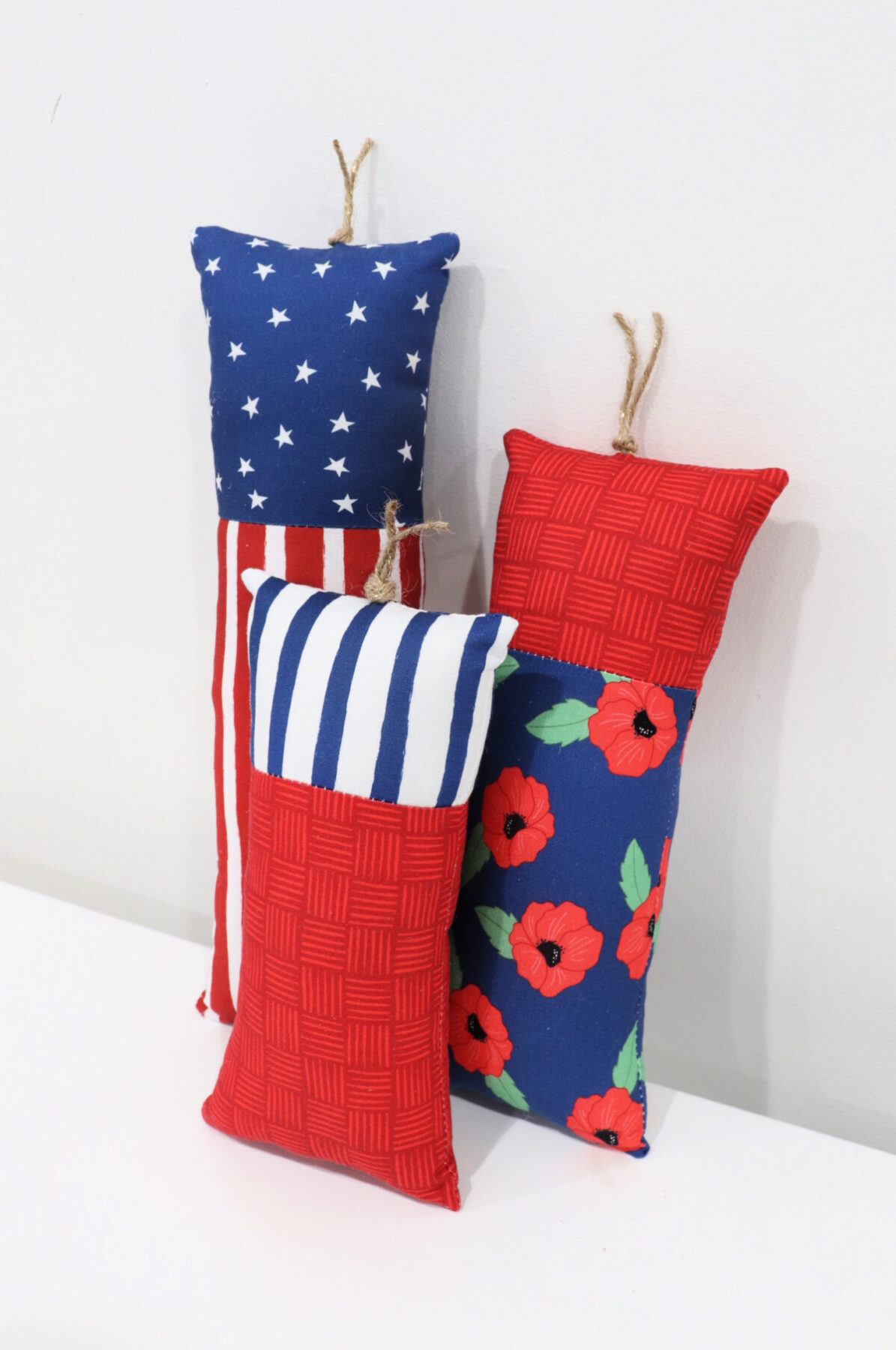 Image contains three plush firecrackers made of patriotic fabric and Poly-Fil.
